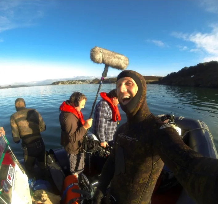 Marine film crew with sound equipment on a boat