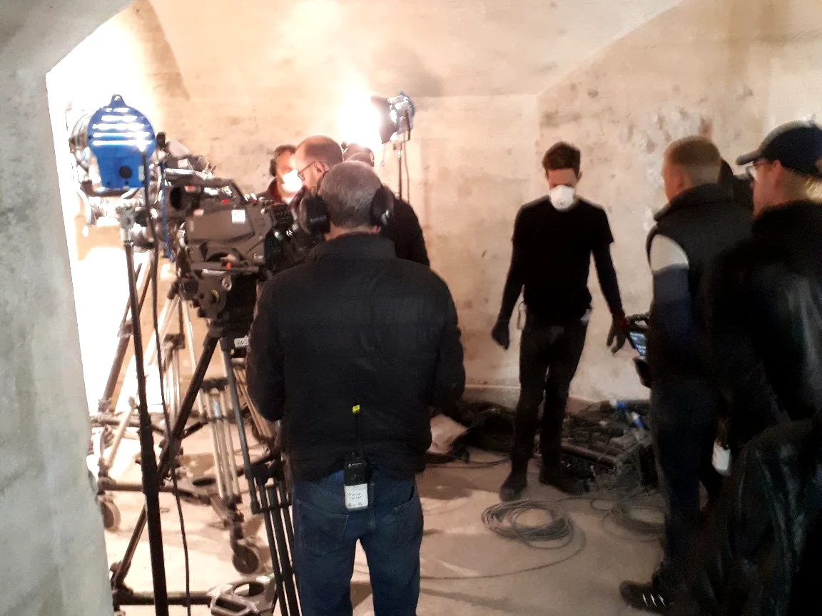 Camera, lighting and production crew working on an indoor shoot